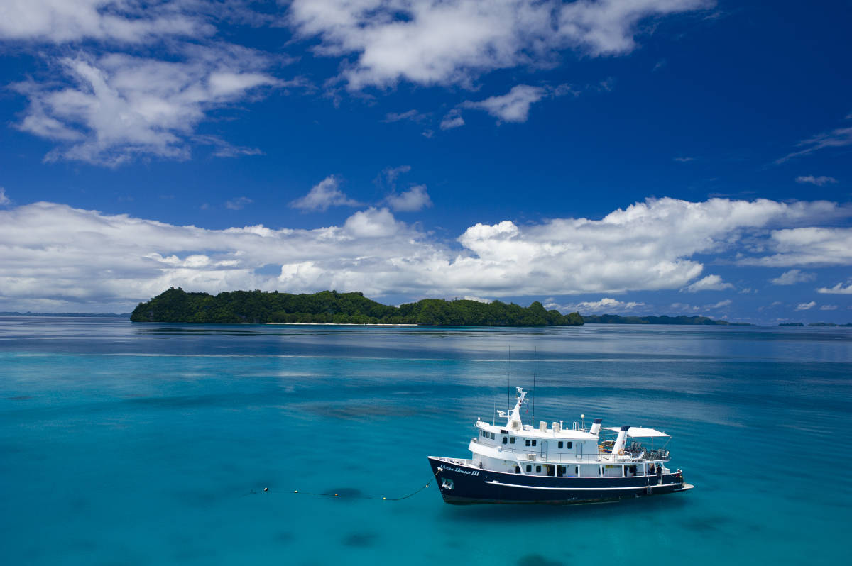 Palau's most luxurious liveaboard the Ocean Hunter 3 in front of one ofe the Rock islands